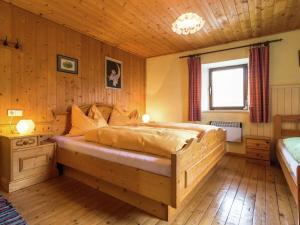 1 dormitorio con 1 cama grande en una habitación con paredes de madera en Spacious Holiday Home in Sankt Johann im Pongau with Garden, en Sankt Johann im Pongau