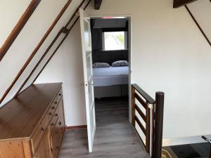 une chambre avec un lit et un escalier avec une porte dans l'établissement Cosy home near the sea with views and south-facing garden, à Tuitjenhorn