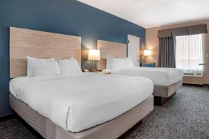 two beds in a hotel room with blue walls at Best Western Navarre Waterfront in Navarre