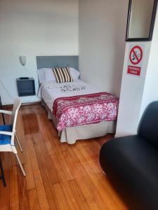 a bedroom with a bed and a table and a chair at Hospedaje Lopez in A Coruña