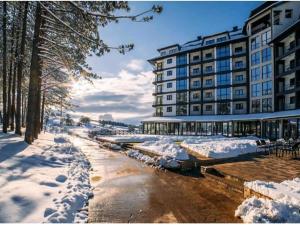 Avantura Studio 1 في زلاتيبور: شارع مغطى بالثلج أمام مبنى كبير
