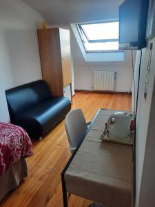 a room with a bed and a couch and a table at Hospedaje Lopez in A Coruña