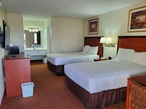 a hotel room with two beds and a television at Motel 6 Shamrock TX in Shamrock