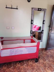 uma cama vermelha num quarto com um espelho em Dar rachid ouzoud em Azilal