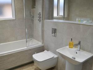 a bathroom with a toilet and a sink and a shower at Serenity Lodge Otterburn in Otterburn +12 photos