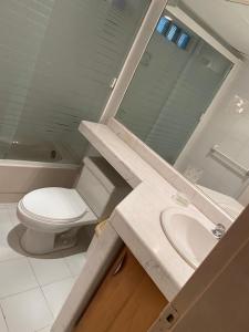 uma casa de banho com um WC branco e um lavatório. em Apartamento con vista al mar em Catia La Mar