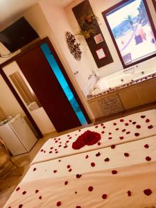 a bedroom with a bed with red roses on it at Pousada Ilha dos Anjos in Florianópolis