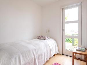 a white bedroom with a bed and a window at Holiday home Kerteminde X in Kerteminde