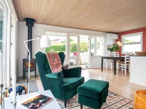 una sala de estar con una silla verde y una mesa en Holiday home Kerteminde X, en Kerteminde