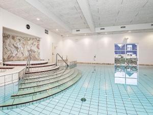 an empty swimming pool with stairs and a painting on the wall at Apartment Skagen XIX in Skagen