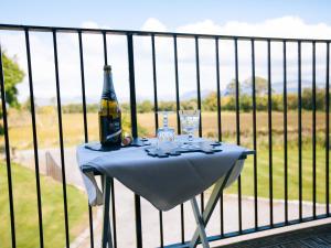 une table avec une bouteille et des verres sur une clôture dans l'établissement Shenavallie Farm, à Benderloch