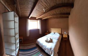 Muyakuelap Eco house & Ecolife في Nuevo Tingo: غرفة نوم بسرير كبير بسقف خشبي