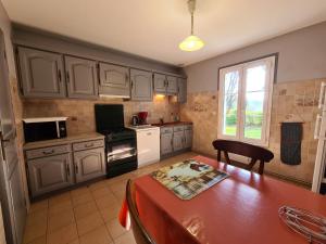 une cuisine avec des placards blancs, une table et une fenêtre dans l'établissement Gîte Villentrois-Faverolles-en-Berry, 5 pièces, 8 personnes - FR-1-591-26, à Villentrois