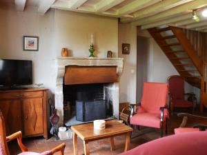 a living room with a fireplace and a tv at Gîte Dampierre-Sous-Brou, 4 pièces, 6 personnes - FR-1-581-19 