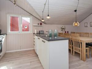 a kitchen and dining room with a table and a counter at 6 person holiday home in Hemmet in Falen