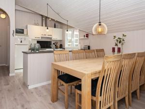 a kitchen and dining room with a wooden table and chairs at 6 person holiday home in Hemmet in Falen