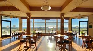 um restaurante com mesas e cadeiras e janelas grandes em Oceanfront Lodge em Crescent City