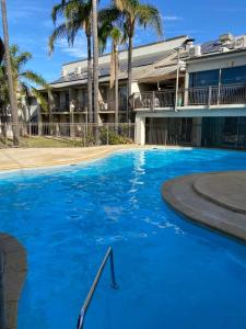 ein großer blauer Swimmingpool vor einem Gebäude in der Unterkunft Paradise Palms in Mandurah + 12 Fotos