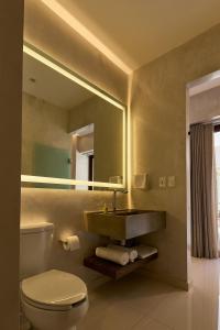 Un baño con lavabo, inodoro y espejo. en Casa Quiote Hotel Boutique City Center based - Adults Only, en Oaxaca City