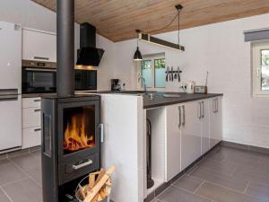 uma cozinha com fogão e lareira em Holiday home Rømø CXXIV em Toftum
