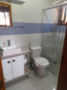 a bathroom with a toilet and a sink and a shower at Casa do Lago in Gramado +13 photos