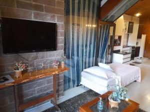 a living room with a flat screen tv on a brick wall at Casa do Lago in Gramado