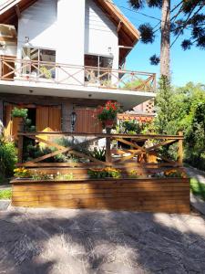 a wooden bench in front of a house at Casa do Lago in Gramado