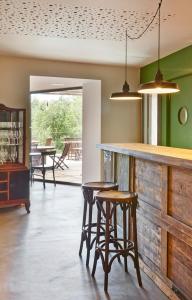 a kitchen with two stools and a bar with chairs at Hotel Restaurant Lotus Priorat in Falset