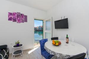 a dining room with a table with a bowl of fruit on it at Apartment Paradise in Postira