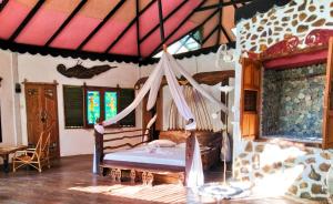 a bedroom with a bed with a hammock in it at Jungle Inn Bukit lawang in Bukit Lawang