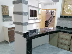 a bathroom with a black counter and a sink at Zom appartement in Dakhla