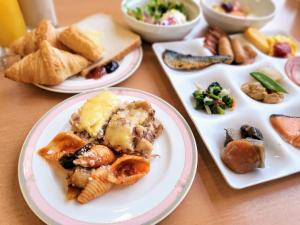 a table topped with plates of food and bowls of food at Blue Port Hotel Kitakyushu Airport in Kanda