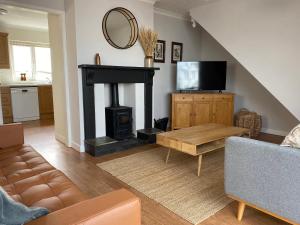 a living room with a fireplace and a television at Auverne in Bude