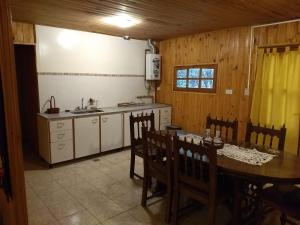 a kitchen with a table and chairs and a sink at Entrepinos Mendoza in Ciudad Lujan de Cuyo