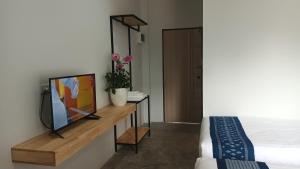 Cette chambre dispose d'une télévision sur une table en bois. dans l'établissement Hug Udon Hotel, à Udon Thani