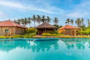 un complexe avec une piscine et des palmiers dans l'établissement Authentic Khmer Village Resort, à Siem Reap