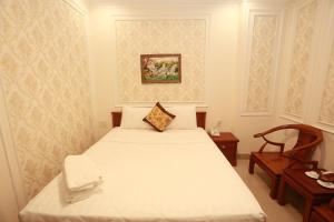 a bedroom with a white bed and a chair at THANH TAI HOTEl 1 in Ho Chi Minh City