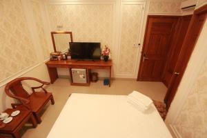 a room with a bed and a desk with a mirror at THANH TAI HOTEl 1 in Ho Chi Minh City