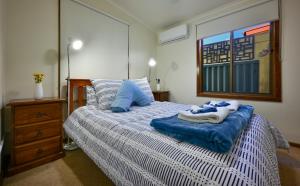 HawkerFlinders Ranges Bed and Breakfast的卧室里有一张床，上面放着蓝色的枕头