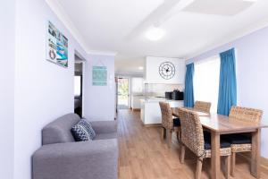 Un comedor y una sala de estar con mesa y sillas. en Forster Holiday Village, en Forster