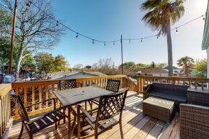 a deck with a table and chairs and a bench at Coastal Comfort in Galveston