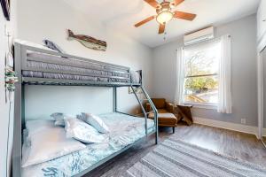 a bedroom with a bunk bed and a ceiling fan at Coastal Comfort in Galveston