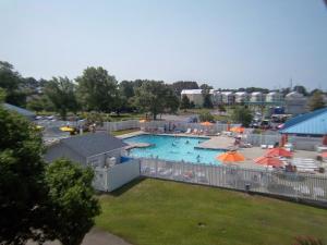 ein großer Pool mit Sonnenschirmen und Menschen darin in der Unterkunft Waterwood Townhouses, a VRI resort in New Bern