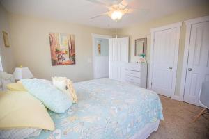 a bedroom with a bed and a ceiling fan at Life's A Beach in Holden Beach