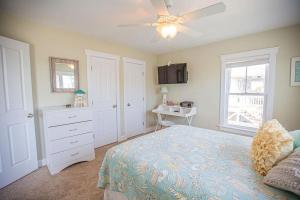 a bedroom with a bed and a ceiling fan at Life's A Beach in Holden Beach