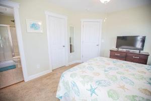a bedroom with a bed and a flat screen tv at Life's A Beach in Holden Beach