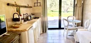 a kitchen with a counter and a table and a window at Relais Grottone in Ostuni