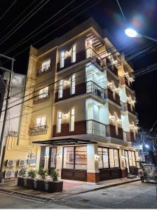 a tall building with windows and balconies at night at Nine Balconies Island Stay in Boac