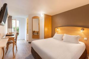 a hotel room with a bed and a desk and a television at Sure Hotel by Best Western Plaisir in Plaisir