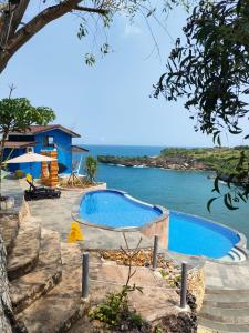 two swimming pools next to a body of water at Baron Lighthouse Cottage & Eatery in Baron